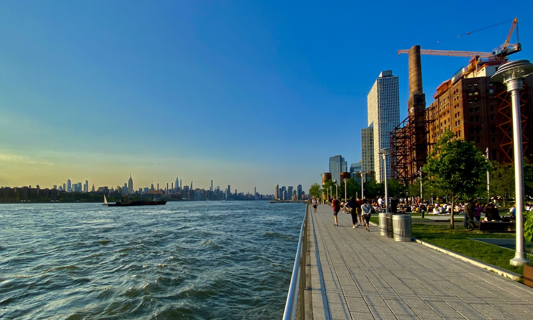 Domino Park waterfront in Williamsburg, Brooklyn, with the East River and Manhattan skyline